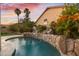 Backyard pool with a rock waterfall feature and lush landscaping at 3102 E Desert Broom Way, Phoenix, AZ 85048