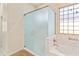 Elegant bathroom featuring glass shower, soaking tub with marble detail, and patterned tile flooring at 3225 E Cardinal Ct, Chandler, AZ 85286