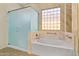 Bright bathroom featuring glass shower, soaking tub, tile flooring, and decorative tiled window at 3225 E Cardinal Ct, Chandler, AZ 85286