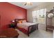 Cozy bedroom with red accent wall, decorative window coverings, and classic wooden furniture at 3225 E Cardinal Ct, Chandler, AZ 85286