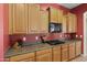 Functional kitchen featuring wooden cabinets, a modern black microwave, and sleek gas cooktop at 3225 E Cardinal Ct, Chandler, AZ 85286