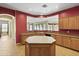 Well-lit kitchen featuring a center island, tan countertops, tan cabinetry, and a pass-through window at 3225 E Cardinal Ct, Chandler, AZ 85286