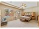 Spacious bedroom with large windows, tray ceiling, and sitting area showcasing tranquil backyard view at 3225 E Cardinal Ct, Chandler, AZ 85286