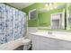 Green bathroom with tub/shower combo, tile floors, and a large mirror at 3444 E Flamingo Ct, Gilbert, AZ 85297