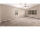Neutral bedroom with carpeting, a ceiling fan, and large windows with blinds at 3444 E Flamingo Ct, Gilbert, AZ 85297
