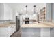 Well-lit kitchen features stainless steel appliances, white cabinetry, stylish countertops, and decorative lighting at 3444 E Flamingo Ct, Gilbert, AZ 85297