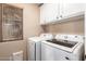 Bright laundry room featuring a full-sized washer and dryer with overhead storage at 3444 E Flamingo Ct, Gilbert, AZ 85297