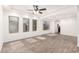 Bright living room with neutral walls, wood-look floors, large windows, and a ceiling fan at 3444 E Flamingo Ct, Gilbert, AZ 85297