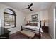 Bedroom featuring a wooden bed frame, ceiling fan, and arched window with blinds at 36674 N Vasari Dr, Scottsdale, AZ 85262