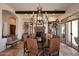 Dining room featuring a large chandelier, fireplace, and outdoor views at 36674 N Vasari Dr, Scottsdale, AZ 85262