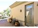 Entrance of a home with tiled roof, stucco wall, potted plants, and decorative lighting at 36674 N Vasari Dr, Scottsdale, AZ 85262