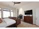 Cozy main bedroom featuring a stone fireplace, tv and ceiling fan at 36674 N Vasari Dr, Scottsdale, AZ 85262