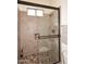 Shower featuring stone tile, glass door, and a built-in shower caddy at 36674 N Vasari Dr, Scottsdale, AZ 85262