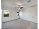 Spacious bedroom featuring neutral carpet, two bright windows, and a ceiling fan at 42099 W Balsa Dr, Maricopa, AZ 85138