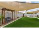 Lush backyard with artificial grass, pergola, decorative gravel, and seating area at 4410 S Grandview Ave, Tempe, AZ 85282