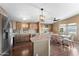 Open kitchen features stainless appliances, center island, wood floors, and pendant lighting over the adjacent dining area at 5735 E Mcdowell Rd # 388, Mesa, AZ 85215