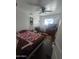 This bedroom features dark wood floors, built in shelving, a ceiling fan, and a white crib by the window at 6010 W Coolidge St, Phoenix, AZ 85033