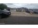 Modest single-story duplex with neutral paint, gravel yard, and American flag accents at 6010 W Coolidge St, Phoenix, AZ 85033
