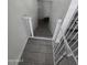 Staircase to the basement with -proof gate in place, and tile steps at 6010 W Coolidge St, Phoenix, AZ 85033