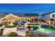 Scenic backyard featuring a pool, patio with lounge chairs, outdoor kitchen, and solar panels on the roof at 6326 W Misty Willow Ln, Glendale, AZ 85310