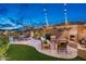 Outdoor patio with fireplace, a pool, turf lawn, and seating area offer a perfect backyard oasis at 6326 W Misty Willow Ln, Glendale, AZ 85310