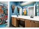 Bright bathroom with a double sink vanity, large mirror, and vibrant floral shower curtain at 6326 W Misty Willow Ln, Glendale, AZ 85310