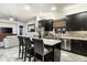 Modern kitchen featuring sleek, dark cabinetry, stainless steel appliances, and an island with seating at 6326 W Misty Willow Ln, Glendale, AZ 85310