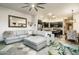 Inviting living room with a large gray sectional, stylish mirror, and open flow to the kitchen at 6326 W Misty Willow Ln, Glendale, AZ 85310