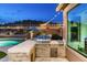 Built-in outdoor kitchen featuring a grill, prep area, and stone accents near the pool at 6326 W Misty Willow Ln, Glendale, AZ 85310
