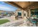 Covered outdoor patio with brick flooring, a ceiling fan, comfortable seating, and seamless indoor/outdoor living at 6326 W Misty Willow Ln, Glendale, AZ 85310