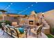 Inviting outdoor living space with a fireplace, comfortable seating, and string lights for a cozy ambiance at 6326 W Misty Willow Ln, Glendale, AZ 85310