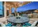 Covered patio with an outdoor fire pit, grill, and landscaped backyard with a pool beyond at 6326 W Misty Willow Ln, Glendale, AZ 85310
