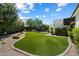 Expansive backyard featuring lush artificial turf, desert landscaping, and cozy patio seating at 7002 E Aster Dr, Scottsdale, AZ 85254