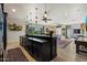 Open concept bar features stylish counter, dark cabinets, backyard views, and adjacent entertainment space at 7002 E Aster Dr, Scottsdale, AZ 85254