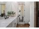 Well-lit bathroom featuring marble countertop, modern sink fixtures, and a decorative door with an elongated mirror at 7002 E Aster Dr, Scottsdale, AZ 85254