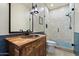 Bathroom featuring dark wood vanity with stone sink, patterned shower tiles, and modern fixtures at 7002 E Aster Dr, Scottsdale, AZ 85254