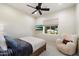 Light and airy bedroom with neutral tones, plush armchair, a wall-mounted TV, and a view to the backyard at 7002 E Aster Dr, Scottsdale, AZ 85254