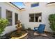 Charming courtyard featuring a stone fountain, blue bench seating, and lush landscaping at 7002 E Aster Dr, Scottsdale, AZ 85254