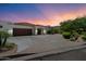 Elegant single-story home showcasing a circular driveway, desert landscaping, and a two-car garage at 7002 E Aster Dr, Scottsdale, AZ 85254