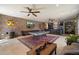 Spacious game room featuring a pool table, brick accent wall, and a stylish bar area for entertaining guests at 7002 E Aster Dr, Scottsdale, AZ 85254