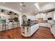 Bright kitchen with white cabinets, dark countertops, a large island, and hardwood flooring at 7002 E Aster Dr, Scottsdale, AZ 85254