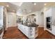 Expansive kitchen featuring a large island, wooden floors, and arched doorways leading to other rooms at 7002 E Aster Dr, Scottsdale, AZ 85254