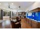 Open living room with an aquarium, brick accent wall, and hardwood floors at 7002 E Aster Dr, Scottsdale, AZ 85254