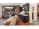 Open living room featuring a wet bar, wine fridge, and brick accent wall at 7002 E Aster Dr, Scottsdale, AZ 85254