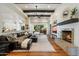 Spacious living room with a fireplace, exposed beams, and seamless indoor-outdoor living to the pool area at 7002 E Aster Dr, Scottsdale, AZ 85254