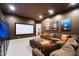 Home theater room with a large screen, plush sofa, decorative pillows, and a custom fish tank at 7002 E Aster Dr, Scottsdale, AZ 85254