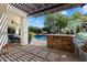 Inviting outdoor kitchen area with a built-in grill, bar, and a view of the sparkling pool at 7002 E Aster Dr, Scottsdale, AZ 85254