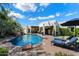 Sparkling pool with rock features, lounge chairs, and lush landscaping for a resort-like backyard oasis at 7002 E Aster Dr, Scottsdale, AZ 85254