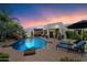 Lush backyard with sparkling pool, waterfall feature, lounge chairs, and outdoor kitchen area at 7002 E Aster Dr, Scottsdale, AZ 85254