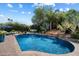 Inviting pool area with rock waterfall and lush landscaping, perfect for outdoor enjoyment and relaxation at 7002 E Aster Dr, Scottsdale, AZ 85254